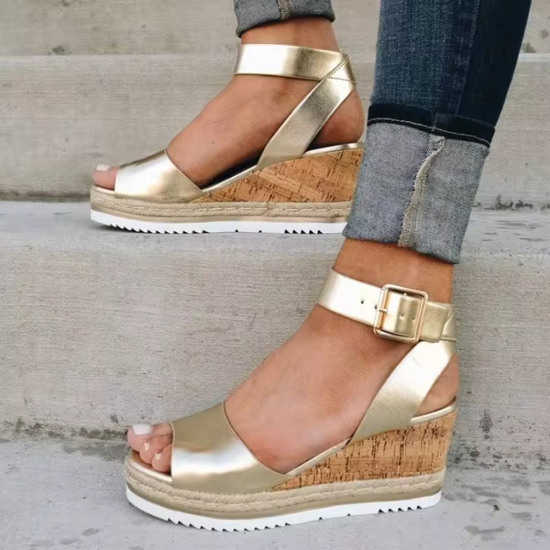 Sandalias elegantes Cassandra de Warszawska Elegancja con tacón de cuña en color neutro, vistas desde el lado en fondo blanco.