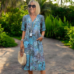 Vestido de primavera Karolína de longitud media de la marca Warszawska Elegancja, con fondo azul y detalles elegantes.