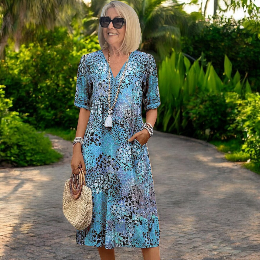 Vestido de primavera Karolína de longitud media de la marca Warszawska Elegancja, con fondo azul y detalles elegantes.