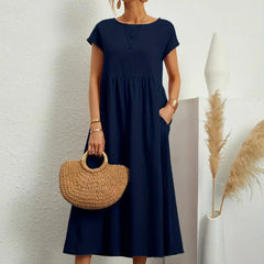 Vestido Irena de Warszawska Elegancja, estilo ligero y femenino, con detalles elegantes y corte favorecedor en color neutro.
