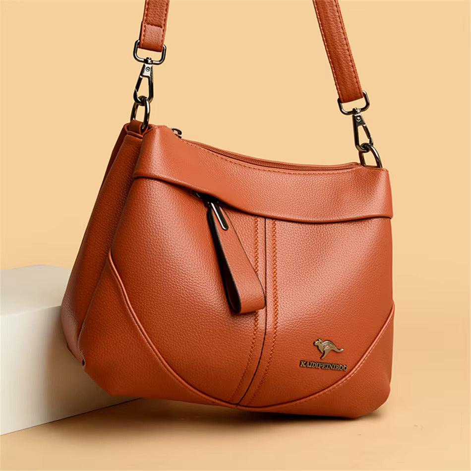 Bolsa de mensajero Aneta de cuero suave en color marrón, diseñada por Warszawska Elegancja, vista desde un lado.