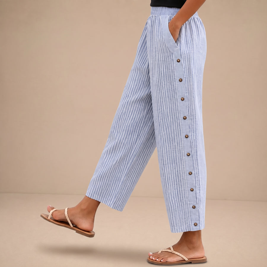 Pantalones a rayas con botones de la marca Warszawska Elegancja, estilo moderno y elegante, con cinturilla ajustada y bolsillos.