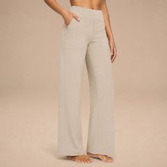 Pantalones cómodos Jasmynne de Warszawska Elegancja, en color neutro, con corte recto y tela suave, en un fondo blanco.