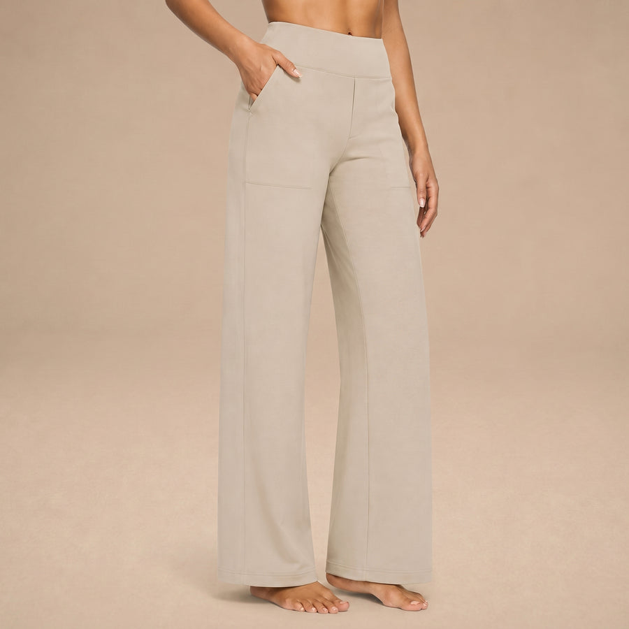 Pantalones cómodos Jasmynne de Warszawska Elegancja, en color neutro, con corte recto y tela suave, en un fondo blanco.