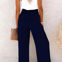Pantalones relajados Riana de Warszawska Elegancja con cintura alta y corte cómodo, en color neutro, en un fondo blanco.