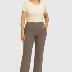 Mujer con pantalones elegantes de la marca Warszawska Elegancja en tono taupe, modelo en estudio, vista frontal.