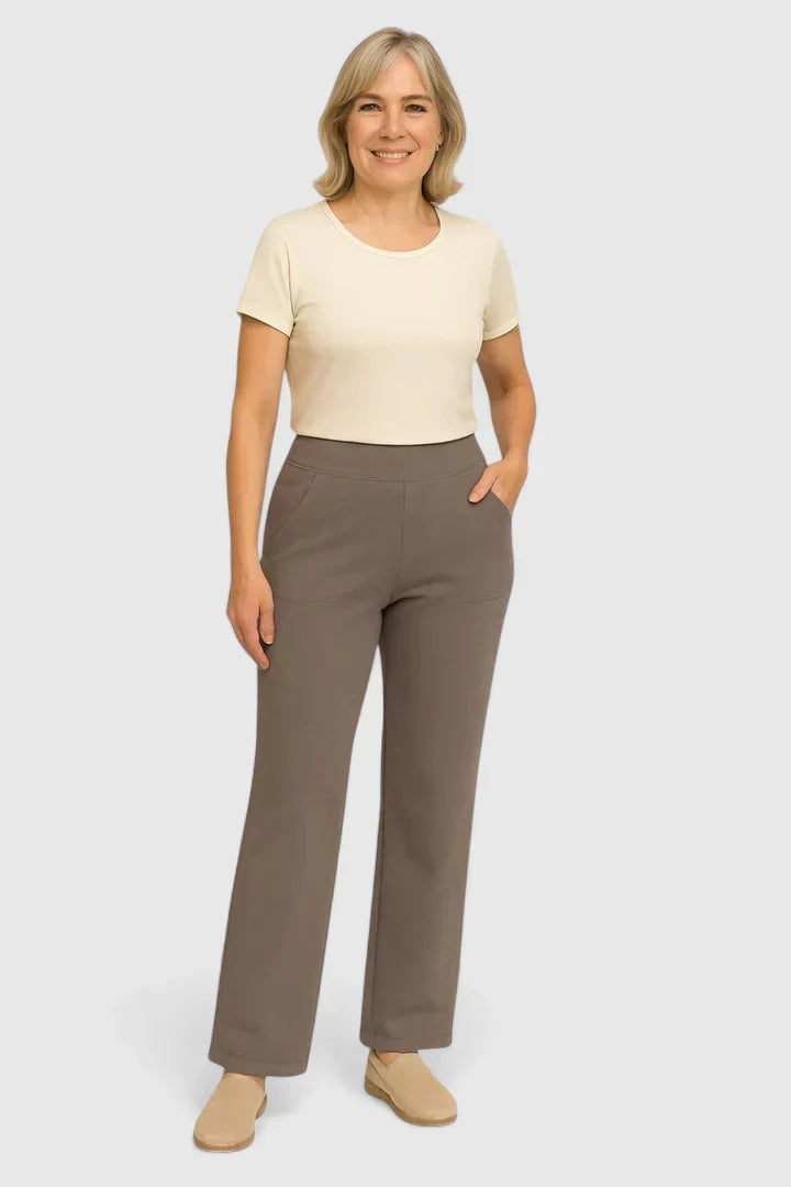 Mujer con pantalones elegantes de la marca Warszawska Elegancja en tono taupe, modelo en estudio, vista frontal.